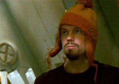 Adam Baldwin as Jayne Cobb in sci-fi series Firefly wearing a distinctive orange and yellow bobble hat with earflaps.