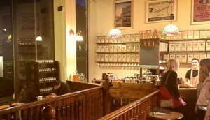 Inside a warm and inviting tea house with a wall full of tea canisters.