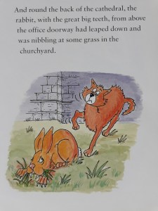 Cartoon of brown rabbit with huge vampire teeth chewing grass.